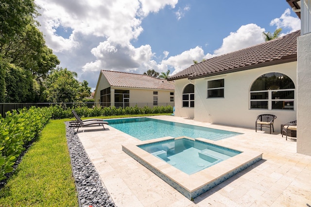 view of pool featuring fence, an in ground hot tub, and a patio area