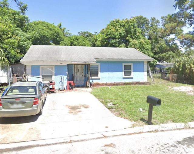 single story home featuring driveway, a front yard, and fence