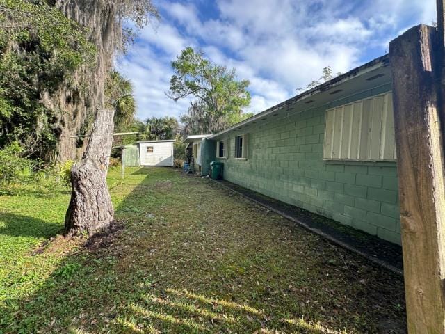 view of yard featuring a storage unit and an outbuilding