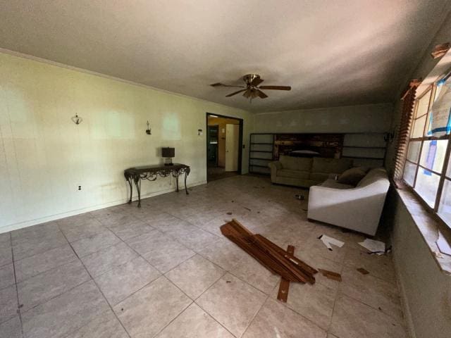 unfurnished living room featuring a ceiling fan and baseboards