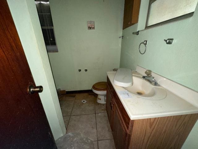 bathroom featuring tile patterned floors, toilet, vanity, and baseboards