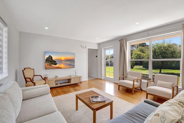 living room with recessed lighting, baseboards, and light wood finished floors