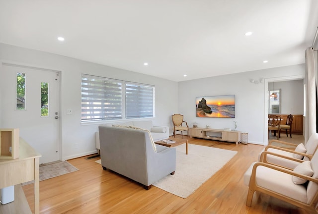 living room with recessed lighting, baseboards, and light wood-style floors