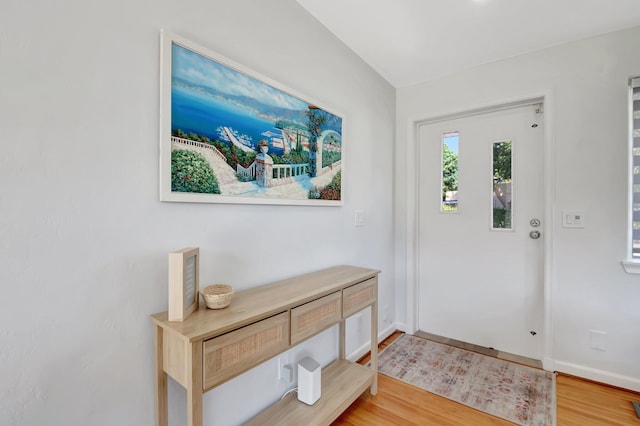 foyer entrance featuring light wood-style flooring and baseboards