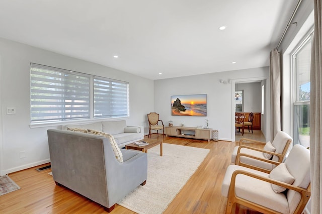 living room featuring light wood-style flooring, recessed lighting, visible vents, and baseboards