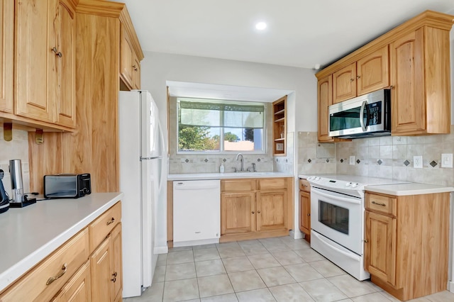 kitchen with white appliances, light countertops, tasteful backsplash, and a sink