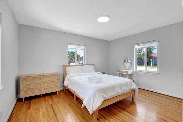 bedroom with light wood finished floors and baseboards