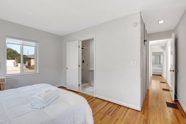 bedroom with light wood-style flooring, baseboards, and visible vents