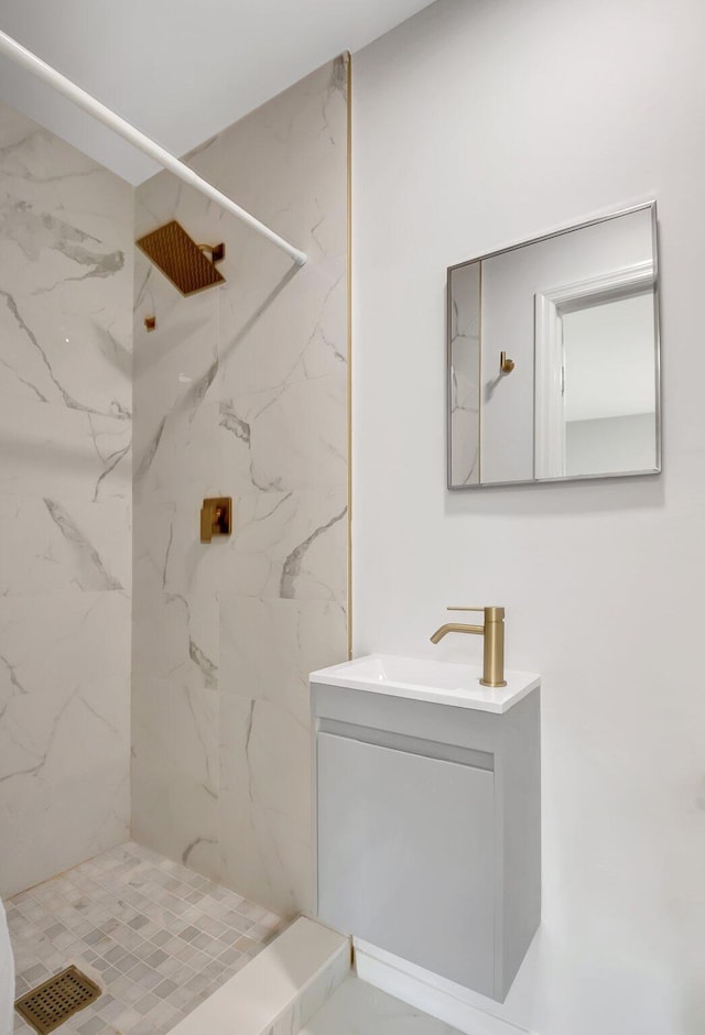 bathroom with vanity and a marble finish shower