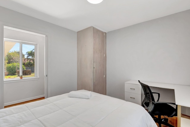 bedroom with wood finished floors and baseboards