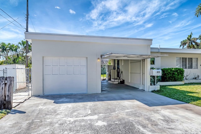 garage featuring driveway and fence