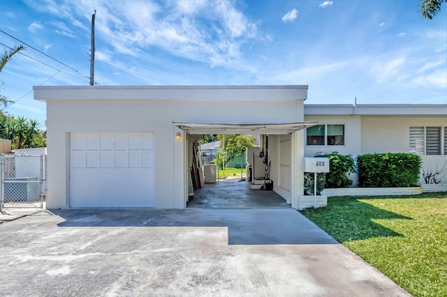 view of front of home with fence, a front yard, stucco siding, driveway, and a gate