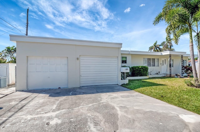 view of front facade featuring stucco siding, a front yard, and a garage