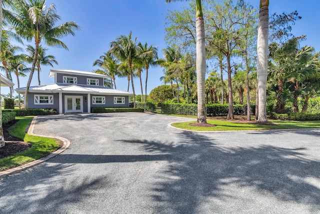 13408 55th St S, Wellington, FL 33449 - view of front of house featuring french doors, curved driveway, and metal roof