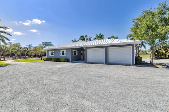 13408 55th St S, Wellington, FL 33449 - view of front of house with a standing seam roof, metal roof, and a garage