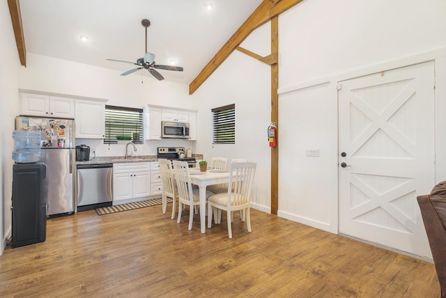 13408 55th St S, Wellington, FL 33449 - kitchen with white cabinetry, beamed ceiling, light wood finished floors, a ceiling fan, and appliances with stainless steel finishes