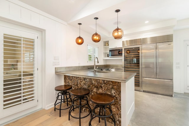 13408 55th St S, Wellington, FL 33449 - kitchen with a sink, built in appliances, a breakfast bar, a peninsula, and stainless steel counters