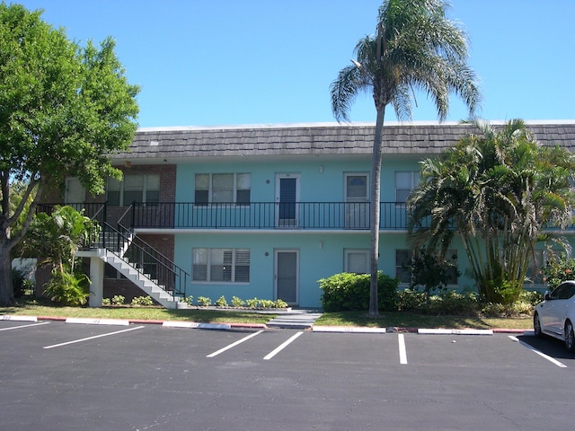 view of building exterior featuring uncovered parking and stairs