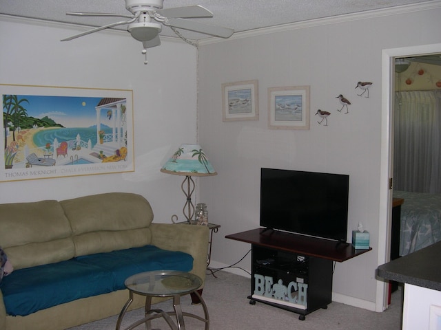 living room with a ceiling fan, ornamental molding, carpet flooring, and a textured ceiling