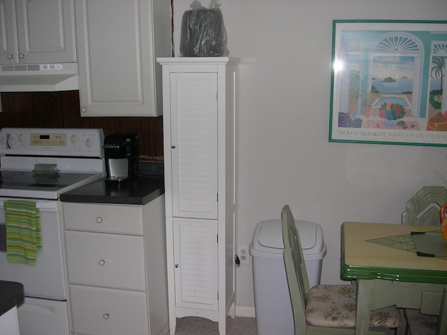 kitchen with white electric range oven, white cabinets, dark countertops, and under cabinet range hood