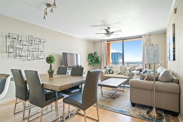 dining area featuring ceiling fan, expansive windows, wood finished floors, and ornamental molding