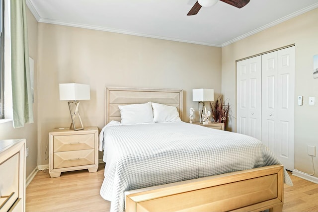 bedroom with a closet, baseboards, light wood-style floors, and ornamental molding