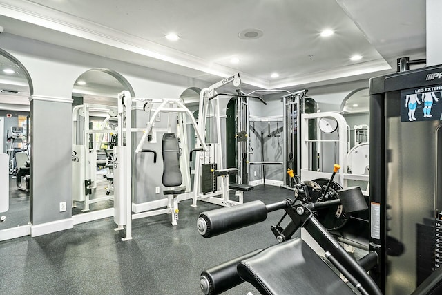 gym featuring a tray ceiling, recessed lighting, baseboards, and ornamental molding