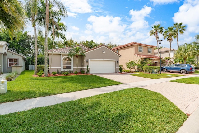 mediterranean / spanish home with stucco siding, a front lawn, driveway, a garage, and a tiled roof