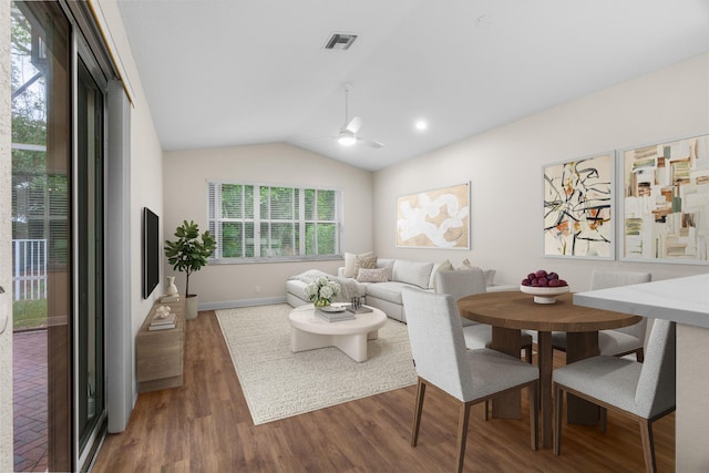 living area featuring wood finished floors, baseboards, visible vents, lofted ceiling, and ceiling fan