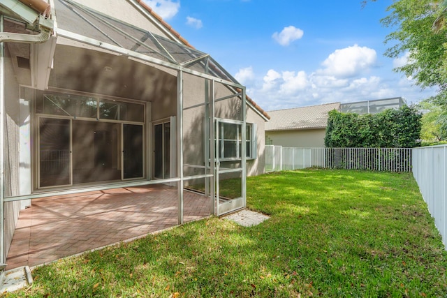 view of yard with glass enclosure, a patio, and a fenced backyard