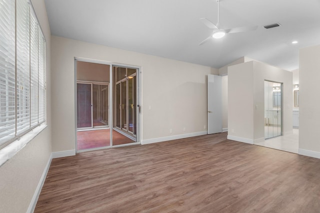 interior space featuring access to exterior, visible vents, baseboards, vaulted ceiling, and wood finished floors