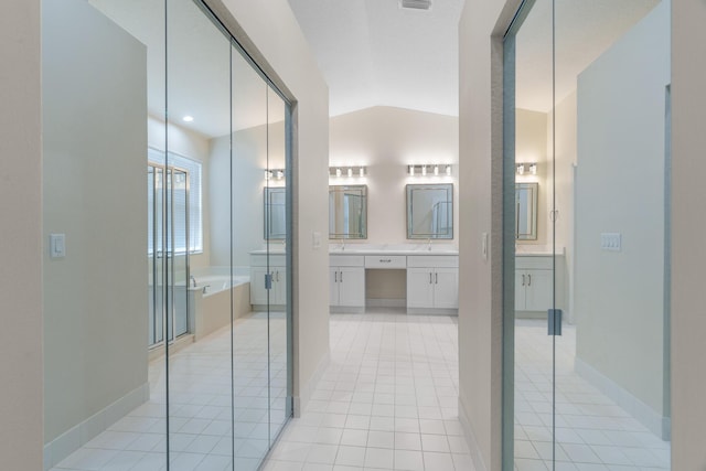 bathroom featuring vanity, visible vents, vaulted ceiling, a garden tub, and tile patterned floors