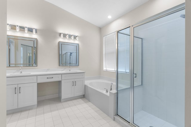 bathroom with double vanity, a stall shower, a bath, and a sink