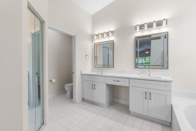 bathroom featuring double vanity, toilet, a garden tub, and a sink