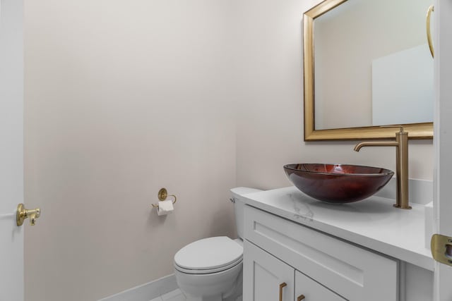 bathroom featuring vanity, toilet, and baseboards