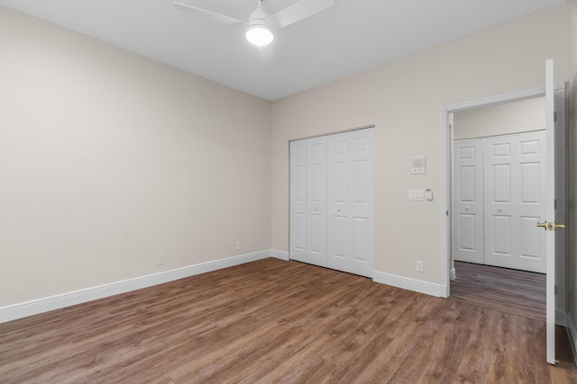 unfurnished bedroom with a closet, baseboards, and wood finished floors