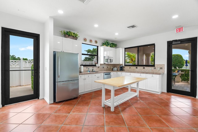 kitchen featuring visible vents, light countertops, decorative backsplash, appliances with stainless steel finishes, and light tile patterned flooring