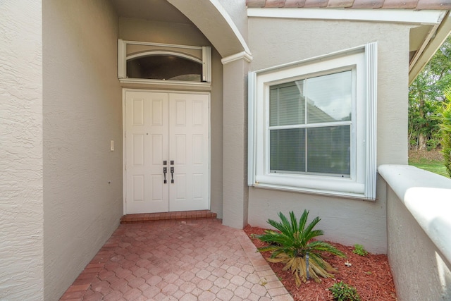 view of exterior entry with stucco siding