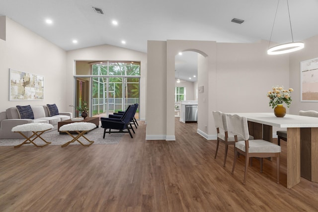 living area featuring visible vents, arched walkways, wood finished floors, and vaulted ceiling