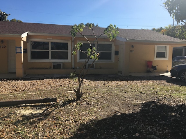 back of property featuring stucco siding and a shingled roof