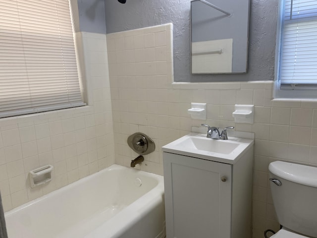 bathroom featuring toilet, tile walls, and a textured wall