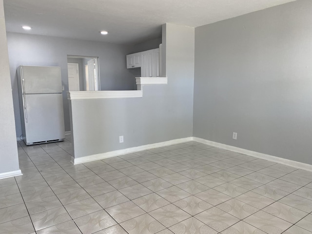 spare room featuring light tile patterned floors, recessed lighting, and baseboards