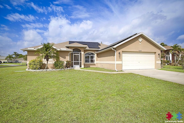 ranch-style house featuring stucco siding, driveway, solar panels, and a front yard