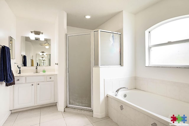 bathroom featuring tile patterned flooring, a shower stall, a bath, and vanity