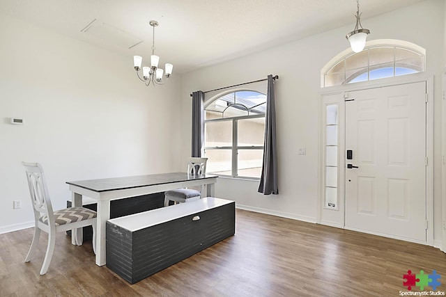 dining space with baseboards, an inviting chandelier, and wood finished floors