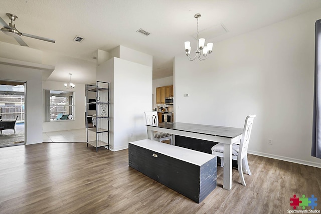 dining area with visible vents, ceiling fan with notable chandelier, baseboards, and light wood-style floors