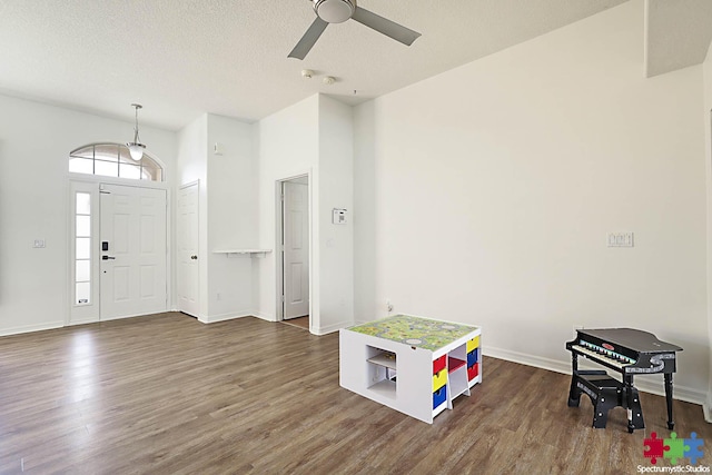 foyer featuring ceiling fan, baseboards, a textured ceiling, and dark wood-style floors