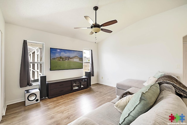 living room featuring vaulted ceiling, baseboards, a ceiling fan, and wood finished floors