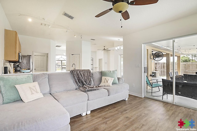 living room featuring visible vents, track lighting, wood finished floors, and a ceiling fan