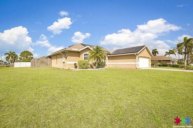 view of front facade with solar panels, a front yard, fence, and stucco siding